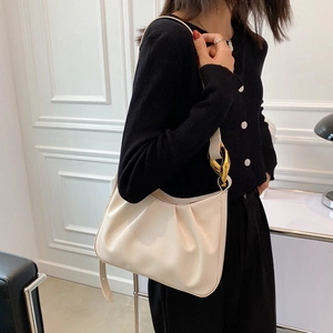 Off-white ruched cloud bucket bag with gold ring hardware on black knit outfit