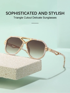 Detail of gradient lenses and golden triangle metal cutout on marble texture sunglasses
