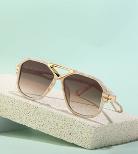 Detail of vintage steampunk oversized sunglasses with beige marble frames and gold bridge