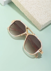 Detailed close-up of marble pattern frame and golden metal bridge on steampunk sunglasses