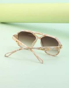 Detail of steampunk aviator sunglasses with marble texture and gold hollow metal accents