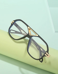 Detail of steampunk black and gold sunglasses with metal bridge on mint green stand