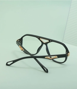 Detail of steampunk sunglasses featuring gold triangle metal accents on black frames
