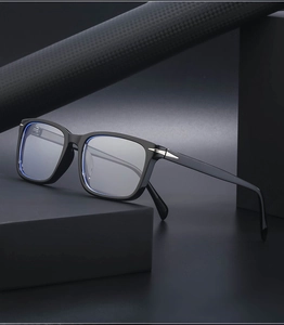 Detail of square black frame sunglasses with silver arrow hardware on carbon fiber background
