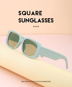 Macro shot of mint green square sunglasses with brown lenses on a pastel pedestal