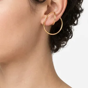 Gold Mobius double layer cuff earrings set on ear model with polished mirror finish
