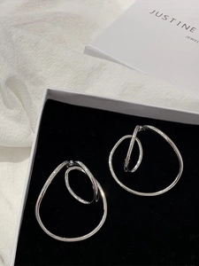 Macro shot of silver Mobius double-layer metal ear clips in a black velvet jewelry box
