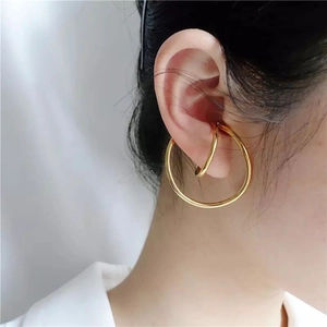 Detailed close-up of golden minimalist Mobius double-layered ear clip on a model ear