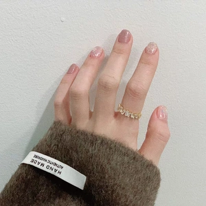 Anello moderno dorato con zirconi taglio baguette indossato sulla mano di una modella