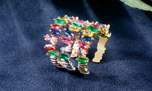 Dettaglio di anelli regolabili in oro, argento e oro rosa con zirconi multicolore