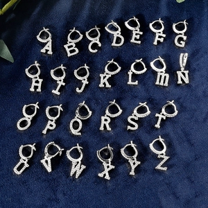 Detailset aus 26 silbernen Alphabet-Ohrringen mit Zirkonia-Besatz auf Samthintergrund