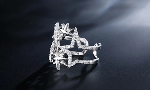 Makroaufnahme eines silbernen offenen Rings mit sternförmigem Muster und Kristallbesatz