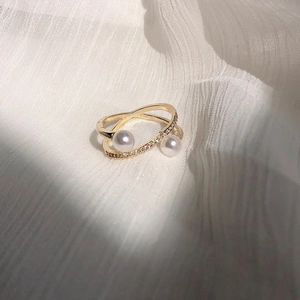 Elegant double-layered gold ring with two pearls and pavé diamonds on textured fabric