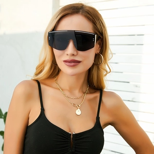 Détail de lunettes de soleil masque oversize avec verres foncés et liseré blanc chic
