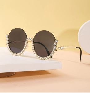 Seitenansicht der runden Damen-Sonnenbrille mit Strassbesatz und goldenen Metallbügeln