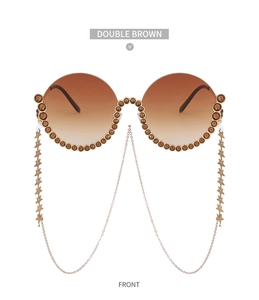 Detail einer runden Strass-Sonnenbrille mit braunen Verläufen und Sternanhänger-Ketten