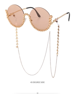Detail der runden Sonnenbrille mit Champagner-Strasssteinen und Stern-Anhänger-Kette
