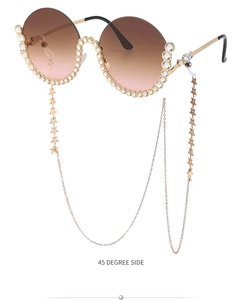 Detail einer luxuriösen runden Verlaufs-Sonnenbrille mit Kristallrand und goldener Kette