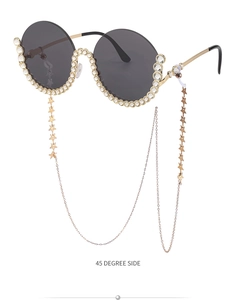 Detailansicht der runden Sonnenbrille mit Strassbesatz und goldener Sternenkette