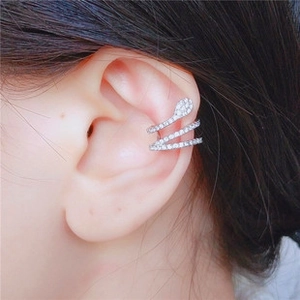 Close-up of silver snake ear cuff with sparkling rhinestones worn on human ear