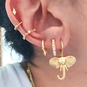 Mini geometric gold earrings set with elephant pendant and pearl stud on ear