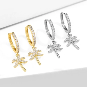 Detailed view of gold and silver coconut tree earrings with sparkling zircon stones