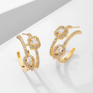 Detail of gold C-shaped earrings with micro-paved zircons and teardrop crystals