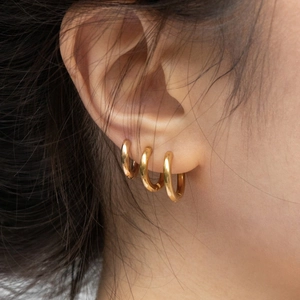 Set de tres pendientes de aro minimalistas en metal dorado pulido de varios tamaños