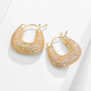 Gros plan de boucles d'oreilles en U plaquées or 18 carats avec zircons cubiques paves