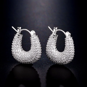 Détail macro de boucles d'oreilles en U serties de zircons cubiques micro-pavés brillants