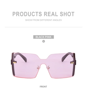 Vue de face de lunettes de soleil oversize sans monture avec verres dégradés roses et branches noires