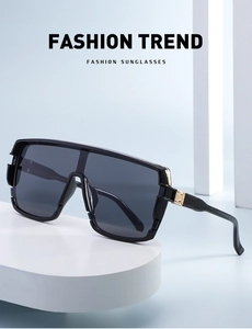 Detail view of fashion oversized sunglasses with golden metal hinges on a display stand