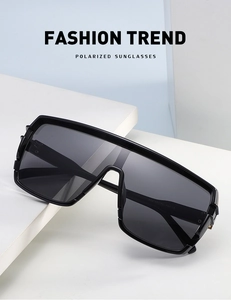 Detail view of fashion oversized black polarized sunglasses with white inner temple text