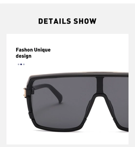 Macro view of oversized flat-top sunglasses showing golden hinge detail and frame texture