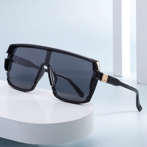 Fashionable oversized wrap-around sunglasses with black frame and gold metal accents