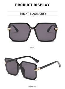 Detail view of square rimless sunglasses with gold metal accents and bright black frame
