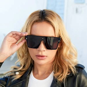 Detailed view of oversized square sunglasses featuring chic golden rivets on black frame