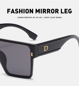 Detailed view of black square sunglasses with gold letter D accent on the temple arm