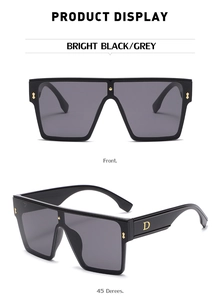 Close-up of oversized black square sunglasses with gold D-logo and metal rivets on temples