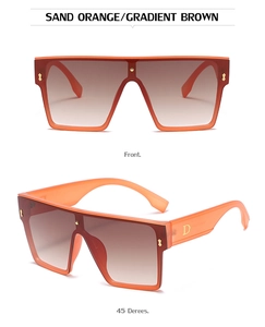 Detail of oversized orange frames with gradient brown lenses and golden metal D-logo