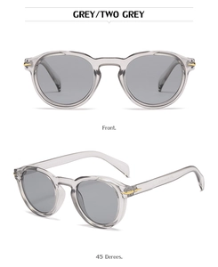 Detail view of grey round frame sunglasses with golden arrow metal hinges and grey lenses