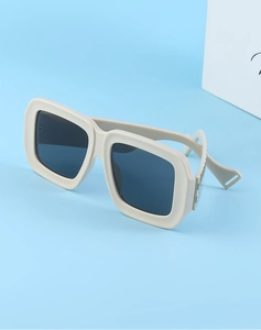Détail de lunettes de soleil carrées crème avec texture tressée sur les branches
