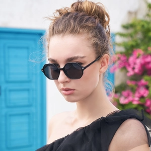 Chic polygonal black sunglasses with dark grey lenses worn by a model in a sunny setting