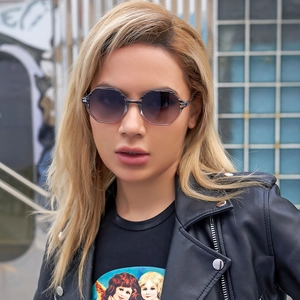Fashionable hexagonal sunglasses with gradient purple lenses on a model in urban style