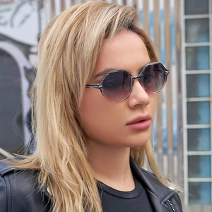 Close-up of trendy polygonal sunglasses with gradient lenses worn by model outdoors