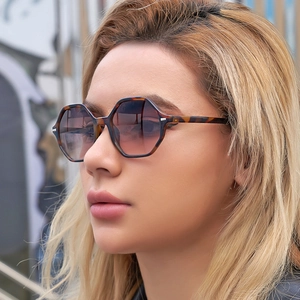 Side view of tortoise shell hexagonal sunglasses with pink gradient lenses on a model