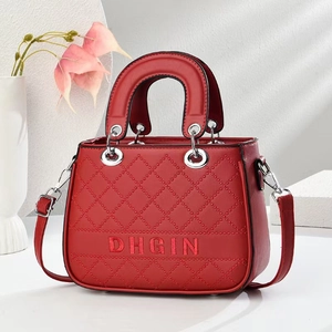 Detail of red quilted handbag with DHGIN embroidery and silver hardware rings