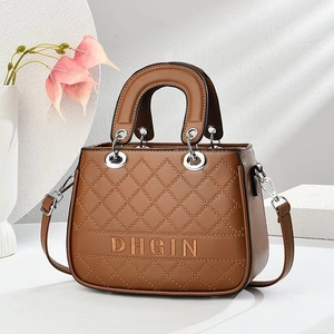 Caramel brown quilted handbag with silver hardware and detachable strap on white background
