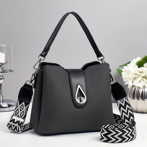 Sac seau gris foncé texturé avec finitions en cuir et bandoulière tissée géométrique