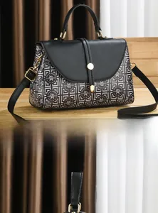 Détail du sac bandoulière imprimé avec rabat en cuir noir et boucle dorée ronde